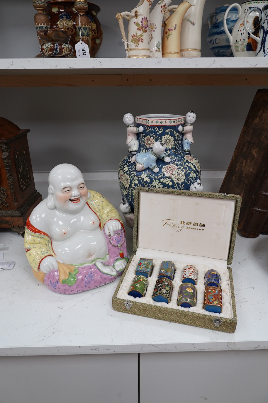 A 20th century Chinese famille rose Buddha, a ‘hundred boys’ vase and a boxed set of cloisonné boxes, vase 34cm. Condition - cloisonné boxes good, Buddha has missing decoration to robe near right hand and vase good